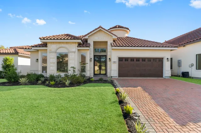 a front view of a house with a yard and garage