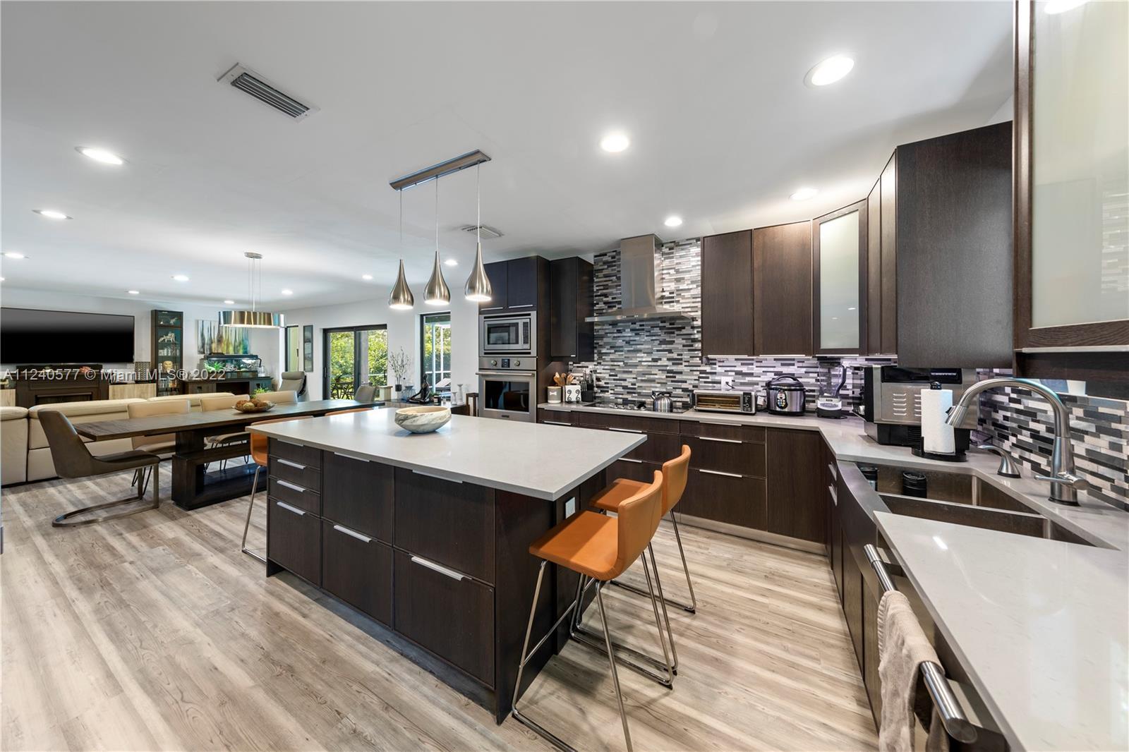 19760 Southwest 242nd Terrace Homestead, FL 33031 - Photo 11 of 49 a kitchen with stainless steel appliances kitchen island granite countertop a sink and cabinets