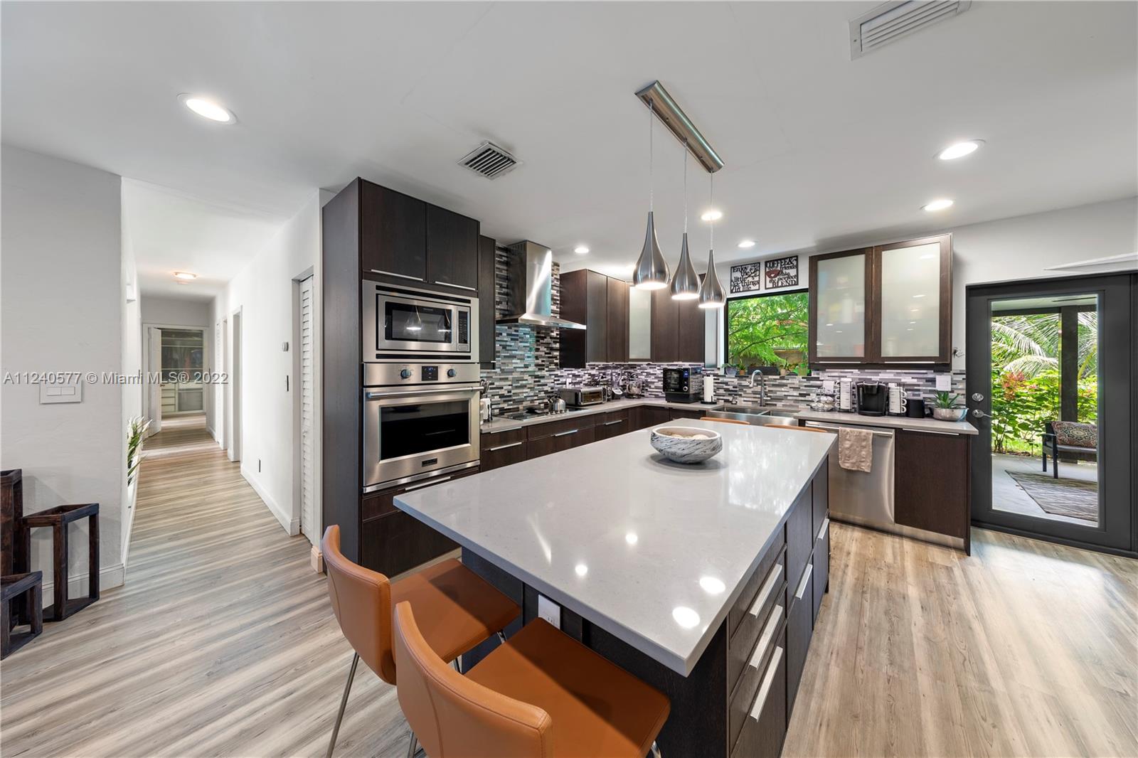 19760 Southwest 242nd Terrace Homestead, FL 33031 - Photo 12 of 49 a kitchen with a table chairs refrigerator and microwave