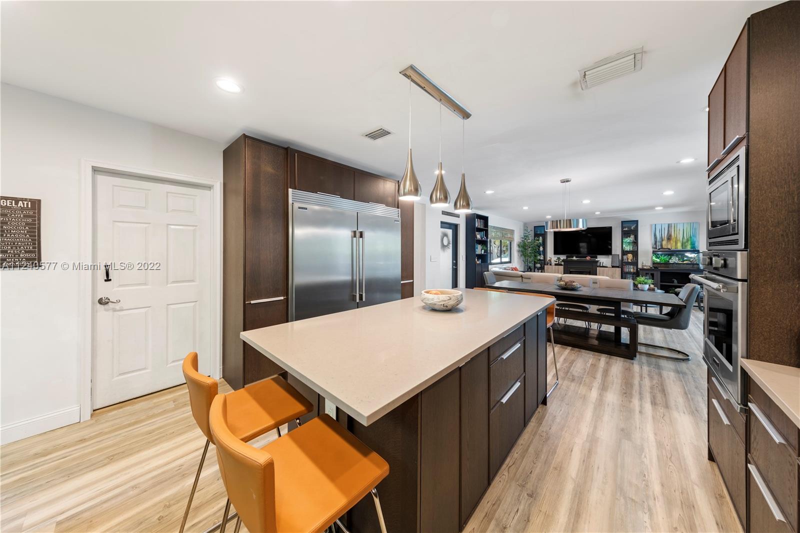 19760 Southwest 242nd Terrace Homestead, FL 33031 - Photo 13 of 49 a kitchen with stainless steel appliances kitchen island granite countertop a table chairs and a refrigerator