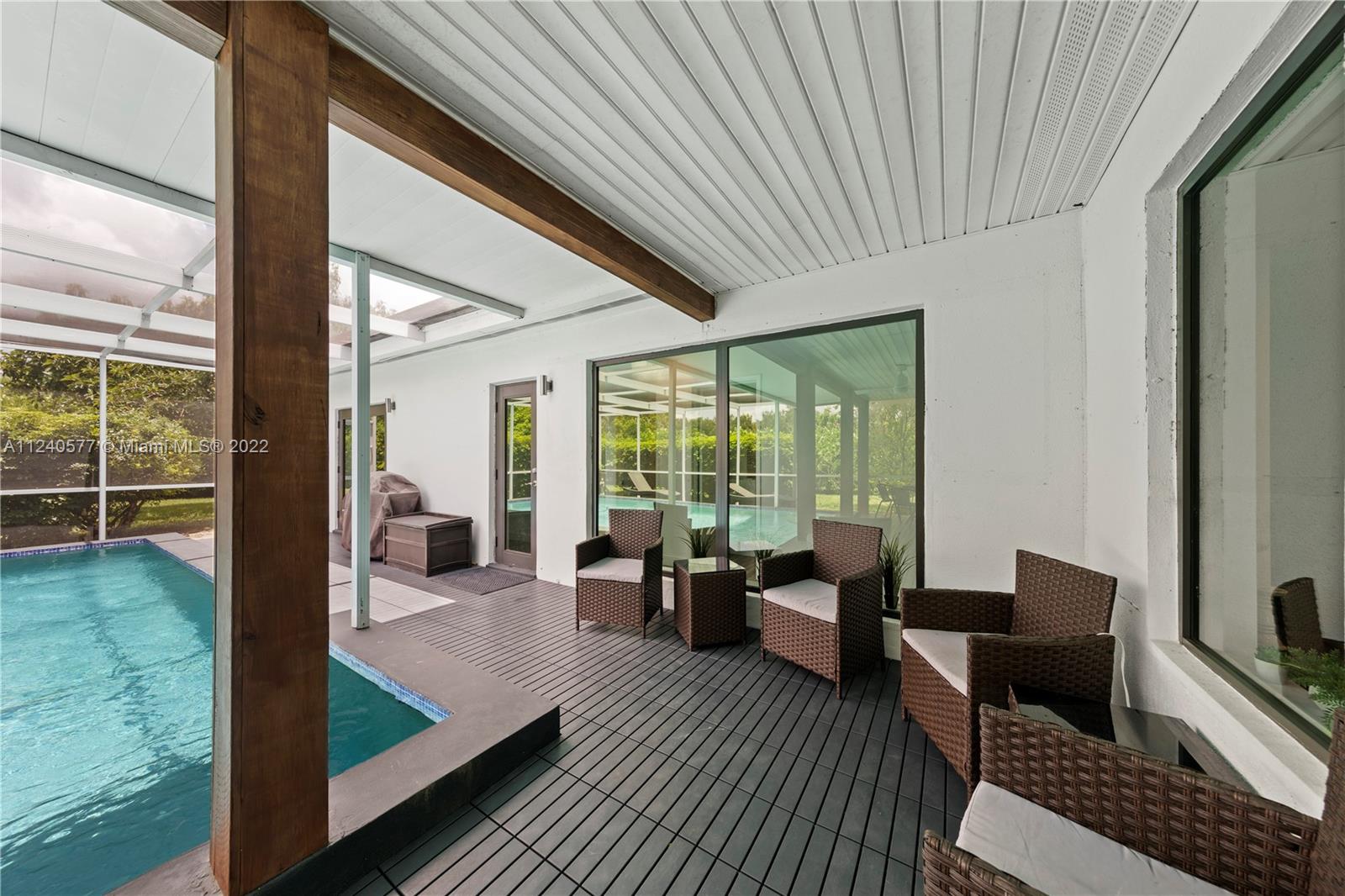 19760 Southwest 242nd Terrace Homestead, FL 33031 - Photo 22 of 49 a living room with furniture floor to ceiling window and wooden floor