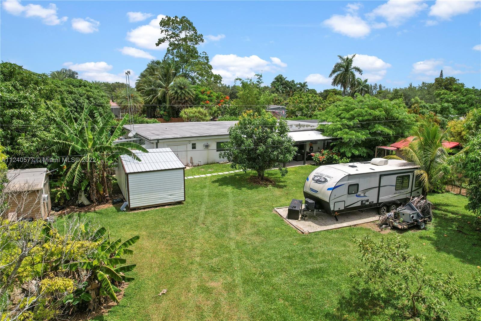 19760 Southwest 242nd Terrace Homestead, FL 33031 - Photo 36 of 49 a car parked in the grass near a house