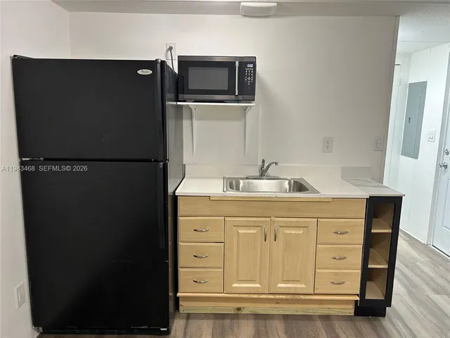 a kitchen with appliances a refrigerator and cabinets