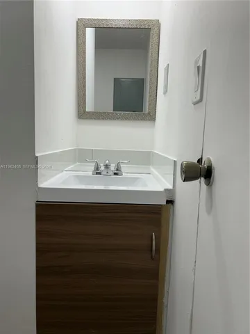 a bathroom with a sink vanity and a mirror