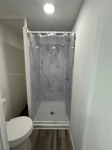 a bathroom with a shower and toilet