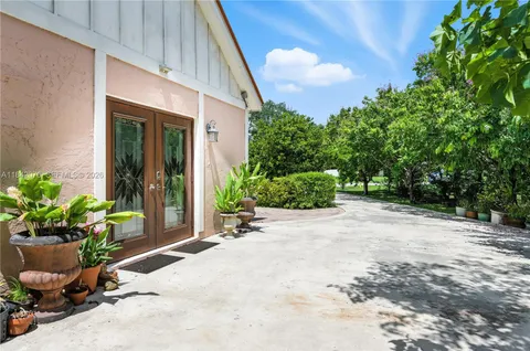 a view of a backyard with potted plants and a bench