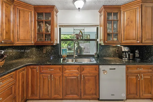 a kitchen with granite countertop cabinets and window
