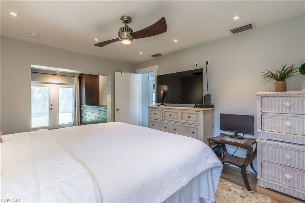 2237 Kings Lake Boulevard Naples, FL 34112 - Photo 18 of 49 a bedroom with a bed and a flat screen tv