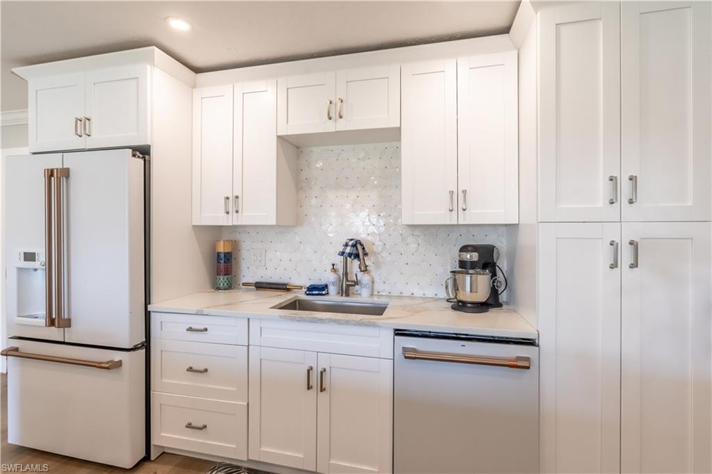 2237 Kings Lake Boulevard Naples, FL 34112 - Photo 3 of 49 a kitchen with stainless steel appliances white cabinets and a refrigerator