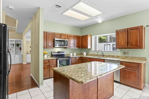 a kitchen with stainless steel appliances granite countertop a sink dishwasher stove top oven and refrigerator