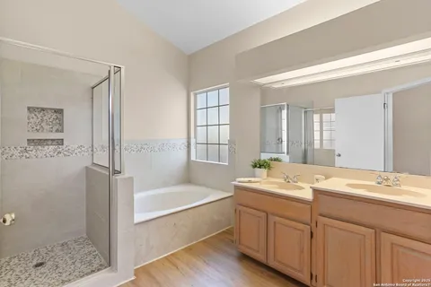 a bathroom with a tub a sink and mirror