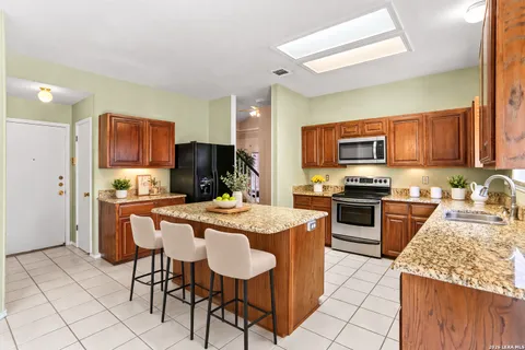 a kitchen with a stove a sink a microwave a dining table and chairs
