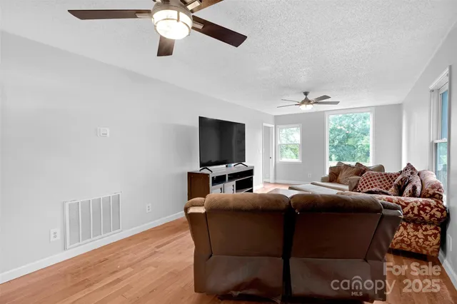 a living room with furniture a ceiling fan and a window