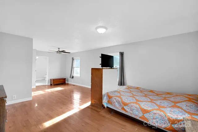 a bedroom with a bed and a view of kitchen
