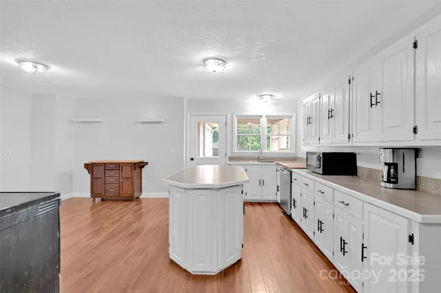 a kitchen with white cabinets appliances and sink