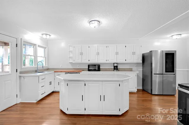 a kitchen with white cabinets and stainless steel appliances
