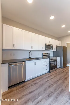 a kitchen with stainless steel appliances a refrigerator sink and microwave