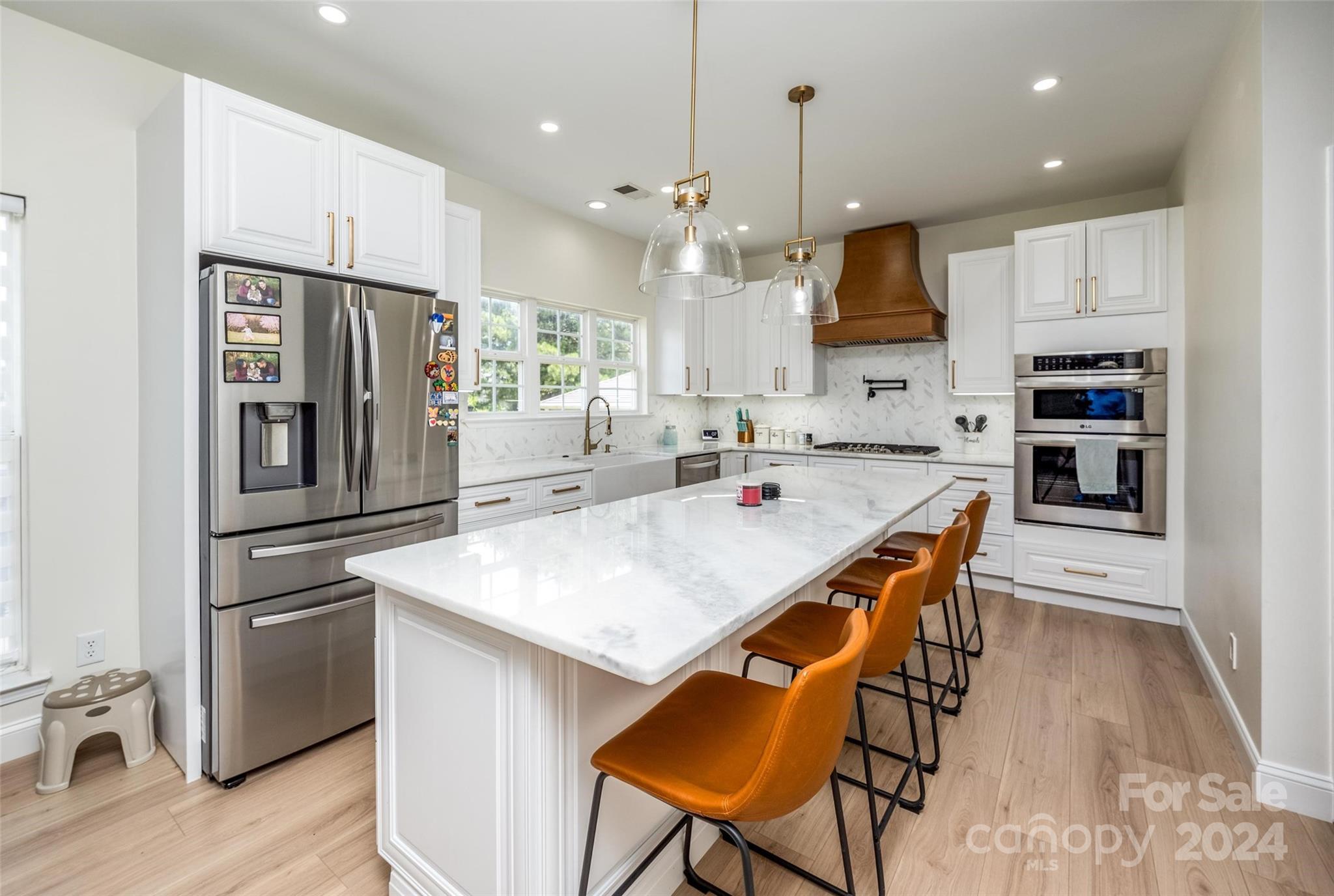 395 Hoover Road Troutman, NC 28166 - Photo 10 of 26 a kitchen with stainless steel appliances granite countertop a sink a stove a refrigerator and island with wooden floor