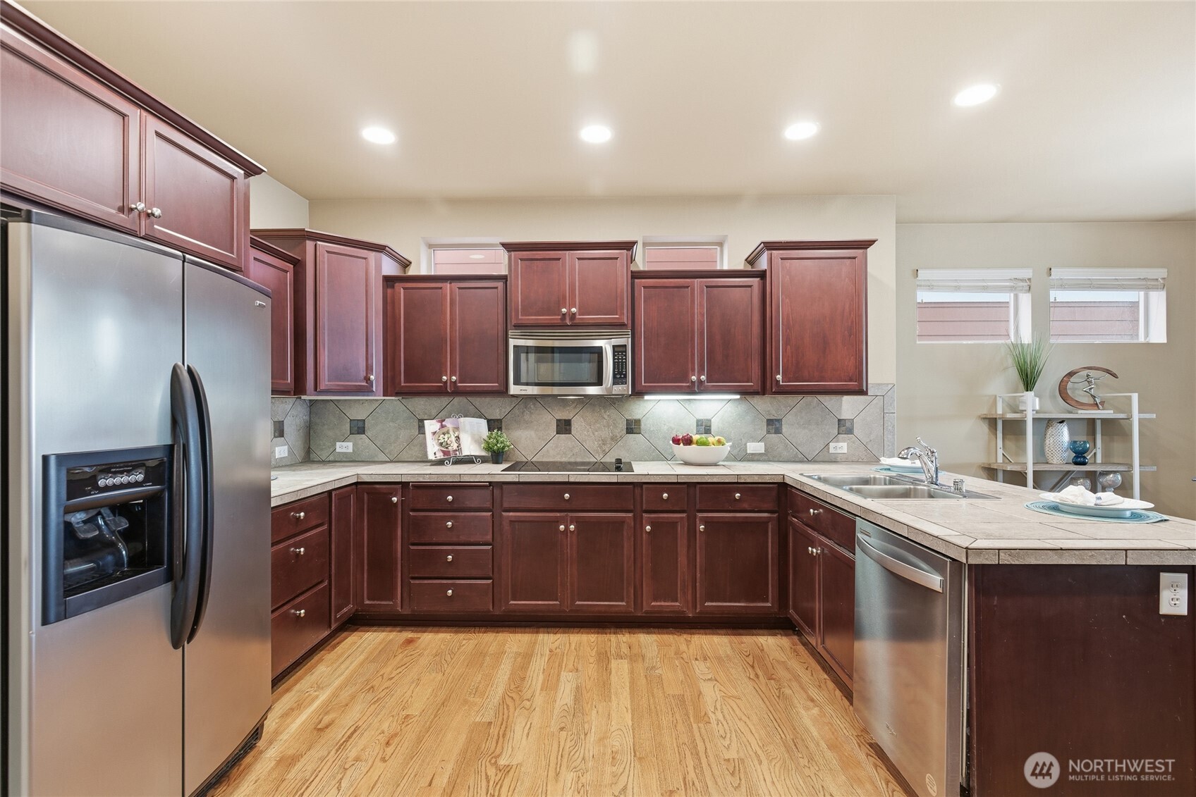 4510 McKinley Street Northeast Lacey, WA 98516 - Photo 6 of 34 a kitchen with stainless steel appliances granite countertop wooden cabinets a sink and dishwasher a refrigerator with wooden cabinets