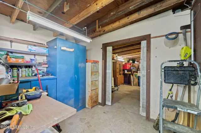 a view of a hallway to room with wooden floor and furniture