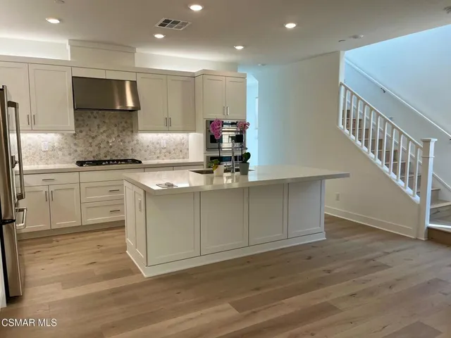 a kitchen with stainless steel appliances granite countertop a stove a sink and a microwave