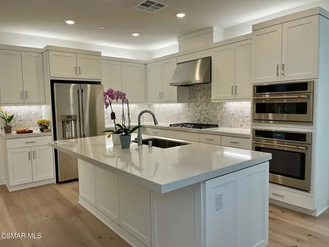 a kitchen with stainless steel appliances a sink stove and refrigerator