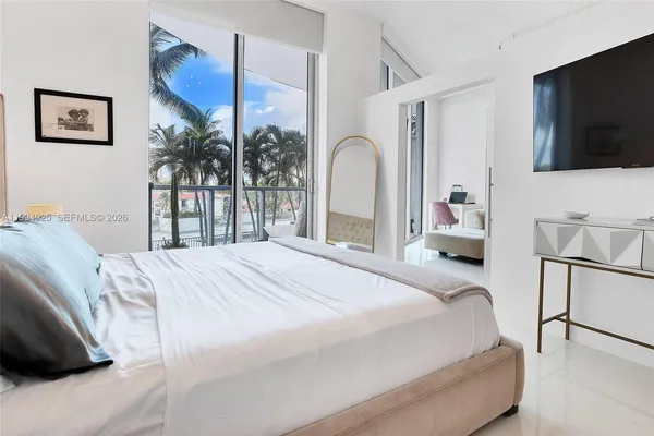 a bedroom with a bed and a flat screen tv