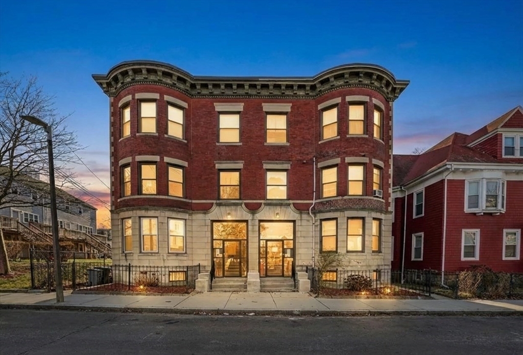 a front view of a residential apartment building with a yard