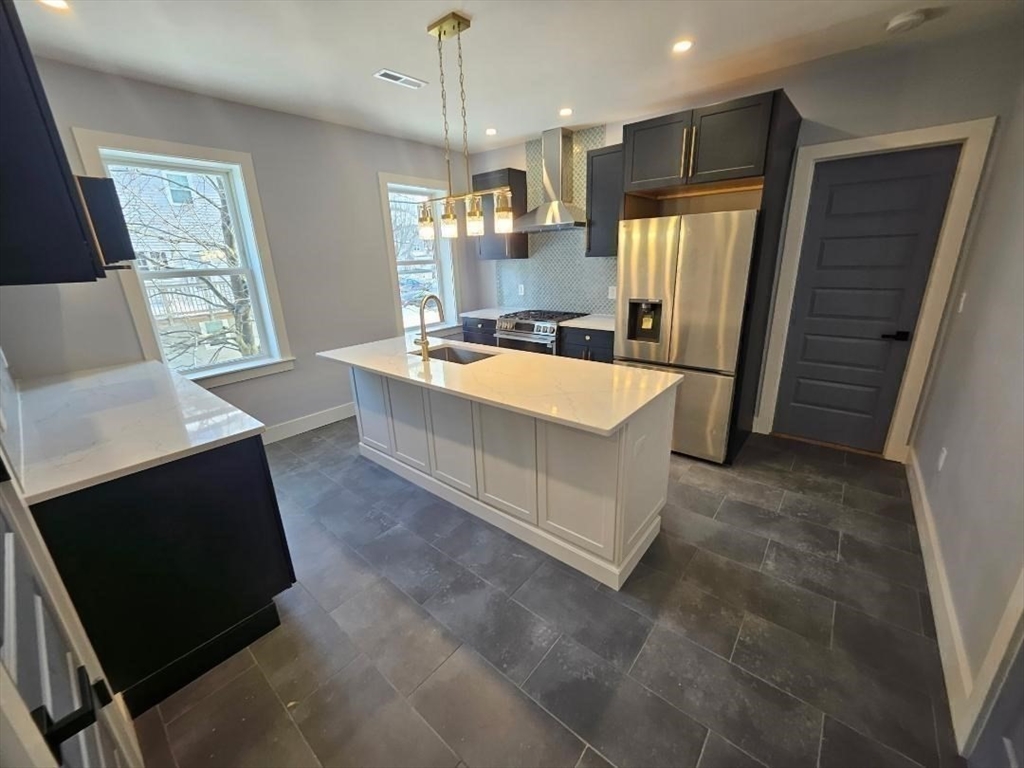 31 Homestead Street, Unit 2 Boston, MA 02121 - Photo 11 of 23 a large kitchen with stainless steel appliances a stove a refrigerator a oven and a fireplace