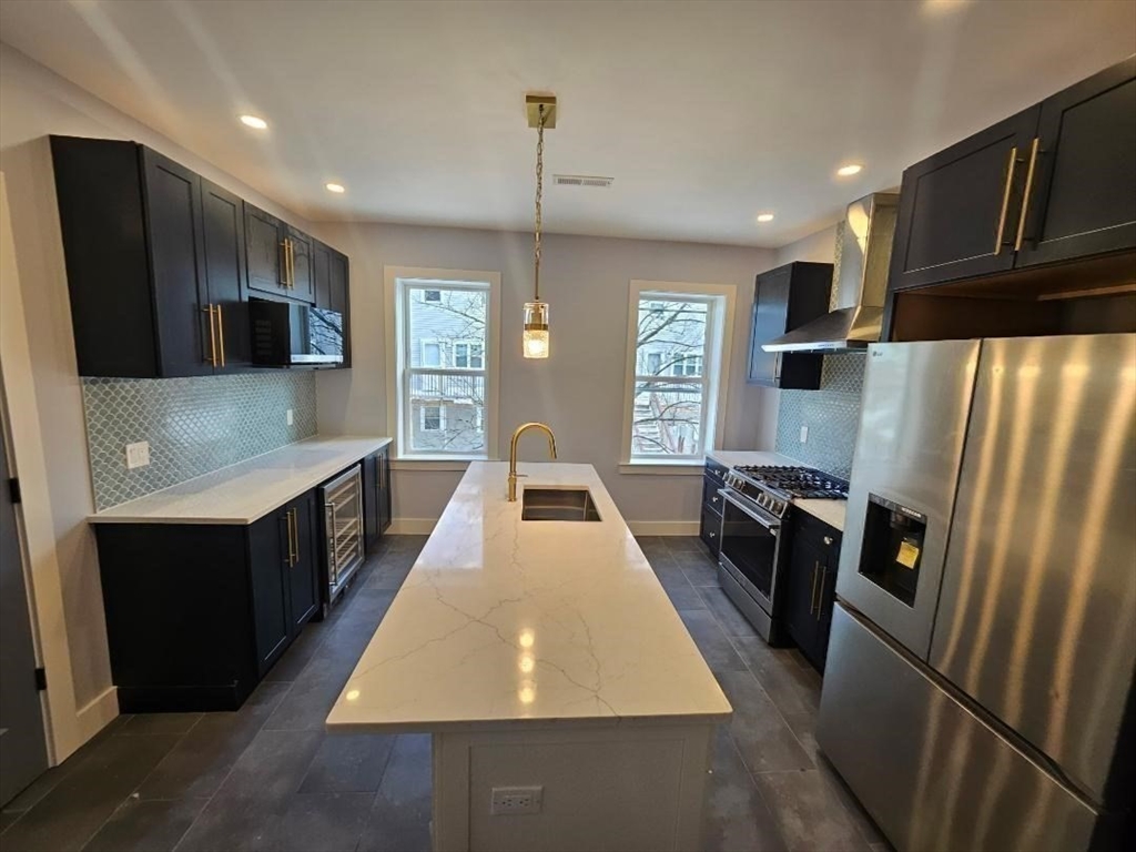 31 Homestead Street, Unit 2 Boston, MA 02121 - Photo 13 of 23 a large kitchen with stainless steel appliances granite countertop a refrigerator a oven a sink counter space and wooden floor