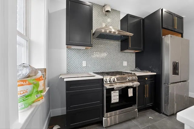 a living room with stainless steel appliances kitchen island granite countertop furniture and a window