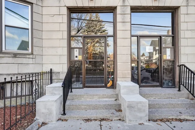a view of a brick house with large windows and couches