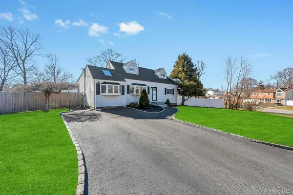 a view of an house with backyard and a tree