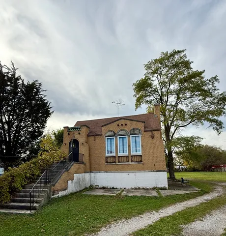 a front view of house with yard and trees around