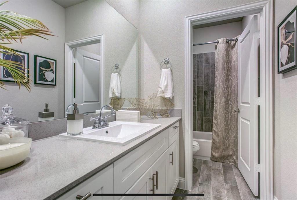 4432 Thalia Way Forney, TX 75126 - Photo 13 of 16 a bathroom with a sink a toilet and a mirror