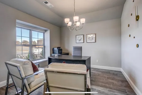 a view of a dining room with furniture a chandelier and wooden floor