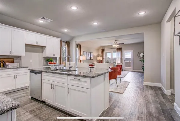 a kitchen with granite countertop a sink and cabinets