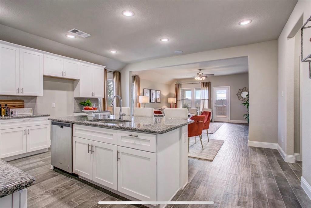4432 Thalia Way Forney, TX 75126 - Photo 3 of 16 a kitchen with granite countertop a sink and cabinets