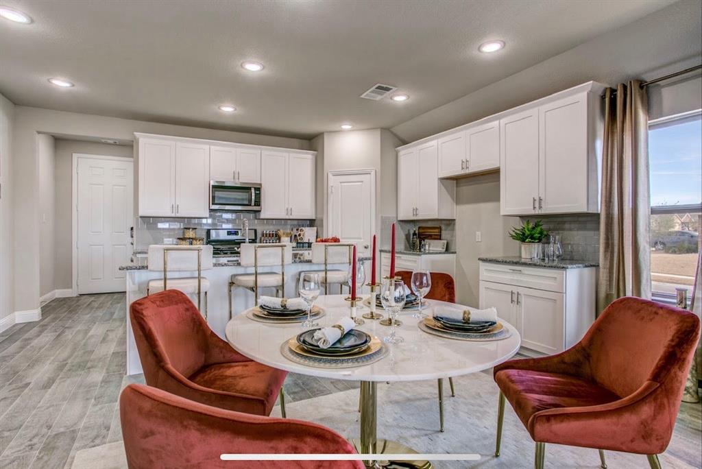 4432 Thalia Way Forney, TX 75126 - Photo 8 of 16 a kitchen with stainless steel appliances kitchen island granite countertop a dining table and chairs