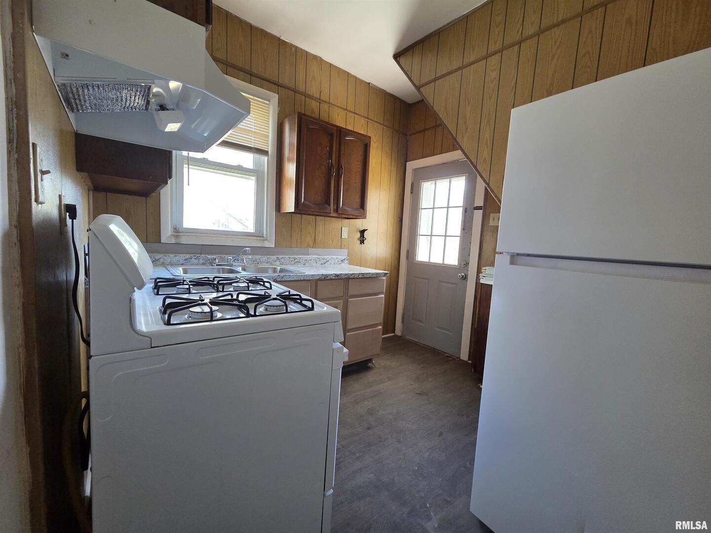 519 4th Avenue South Clinton, IA 52732 - Photo 14 of 16 a kitchen with stainless steel appliances granite countertop a refrigerator a sink dishwasher a stove and white countertops with wooden floor