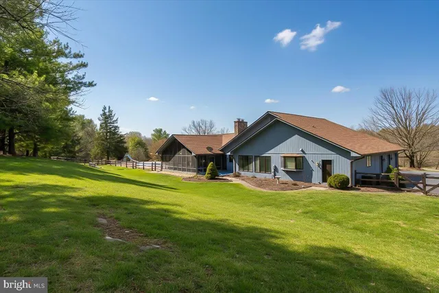 an aerial view of a house with swimming pool and large trees