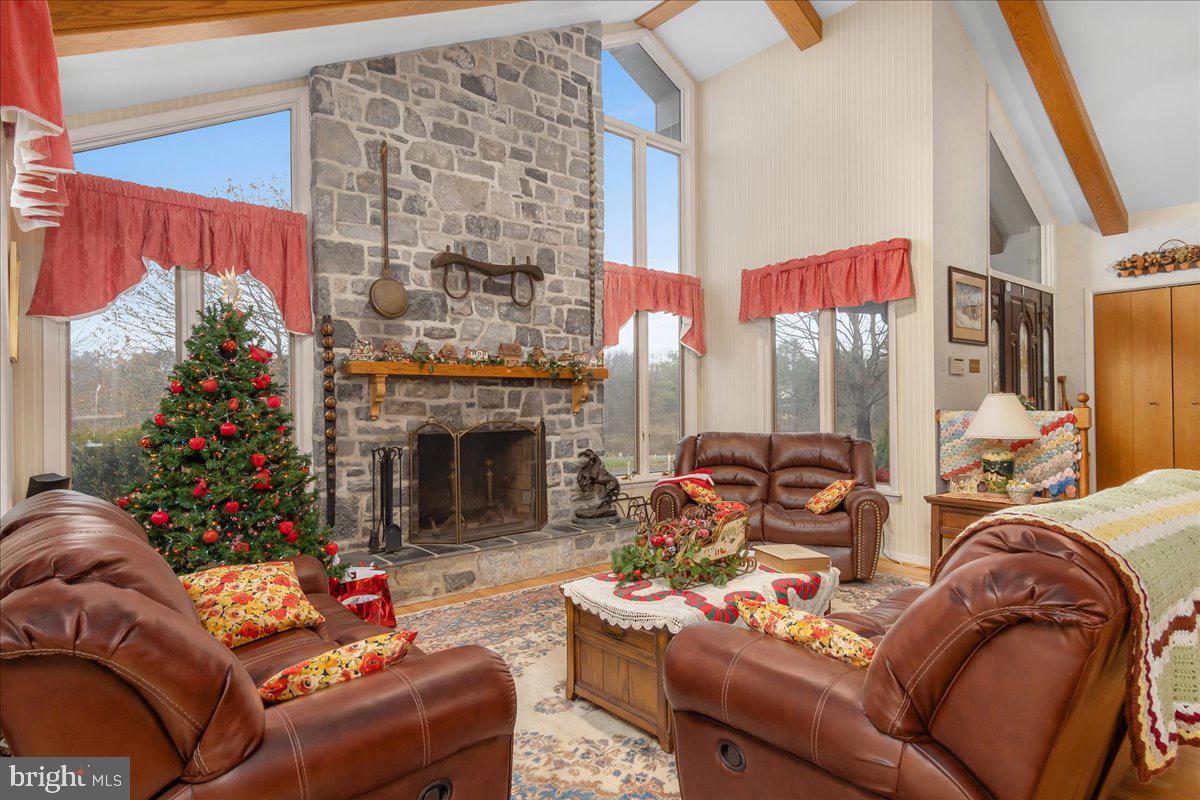 19850 Cool Hollow Road Hagerstown, MD 21740 - Photo 8 of 63 a living room with furniture a fireplace and a floor to ceiling window