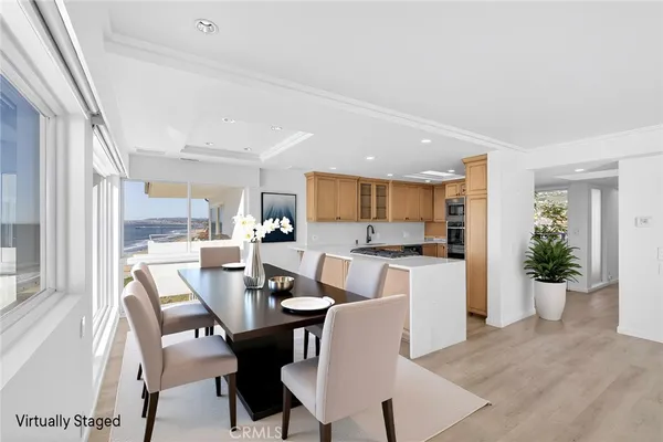 a view of a dining room and livingroom with furniture wooden floor and a rug