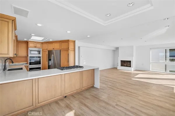 a large white kitchen with stainless steel appliances granite countertop a sink and a stove