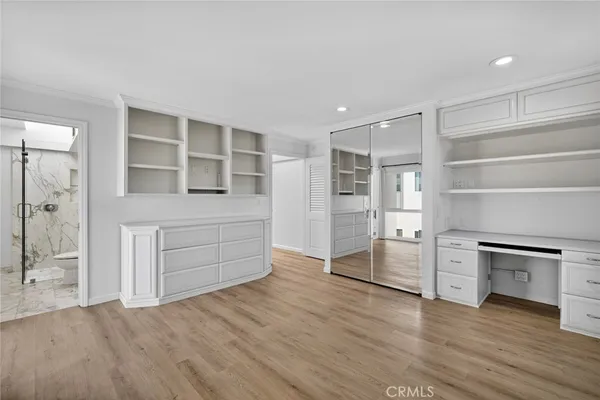 an empty room with wooden floor and cabinet