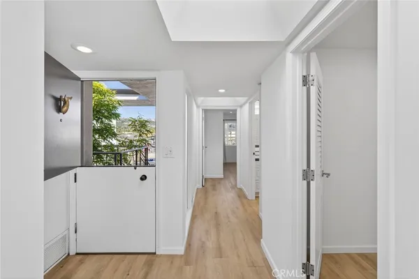a view of a hallway with wooden floor and closet