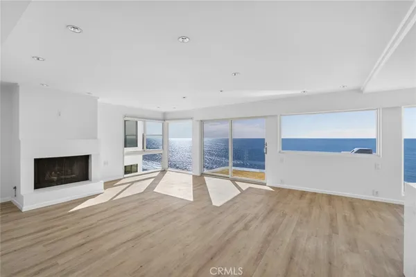 an empty room with wooden floor and fireplace