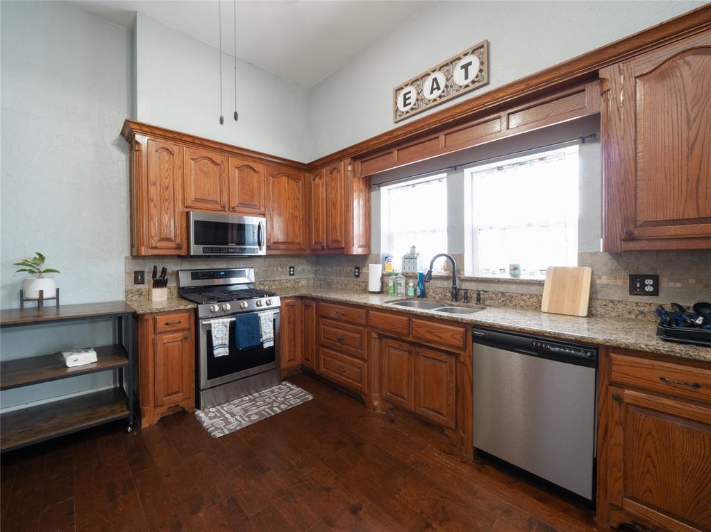 7321 North State Highway Blue Ridge, TX 75424 - Photo 23 of 30 a kitchen with kitchen island granite countertop a sink cabinets stainless steel appliances and a window