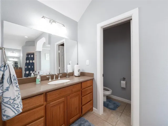a bathroom with a granite countertop sink mirror and toilet