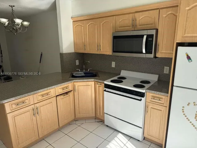 a kitchen with granite countertop white cabinets and black appliances